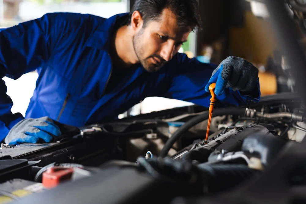 Mechanic checking car engine oil